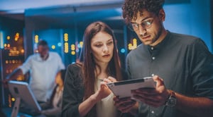 Two people looking at a tablet together
